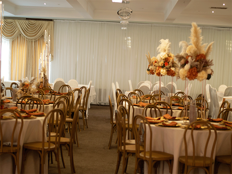 Boho wedding reception with bentwood chairs and autumn pampas centrepieces