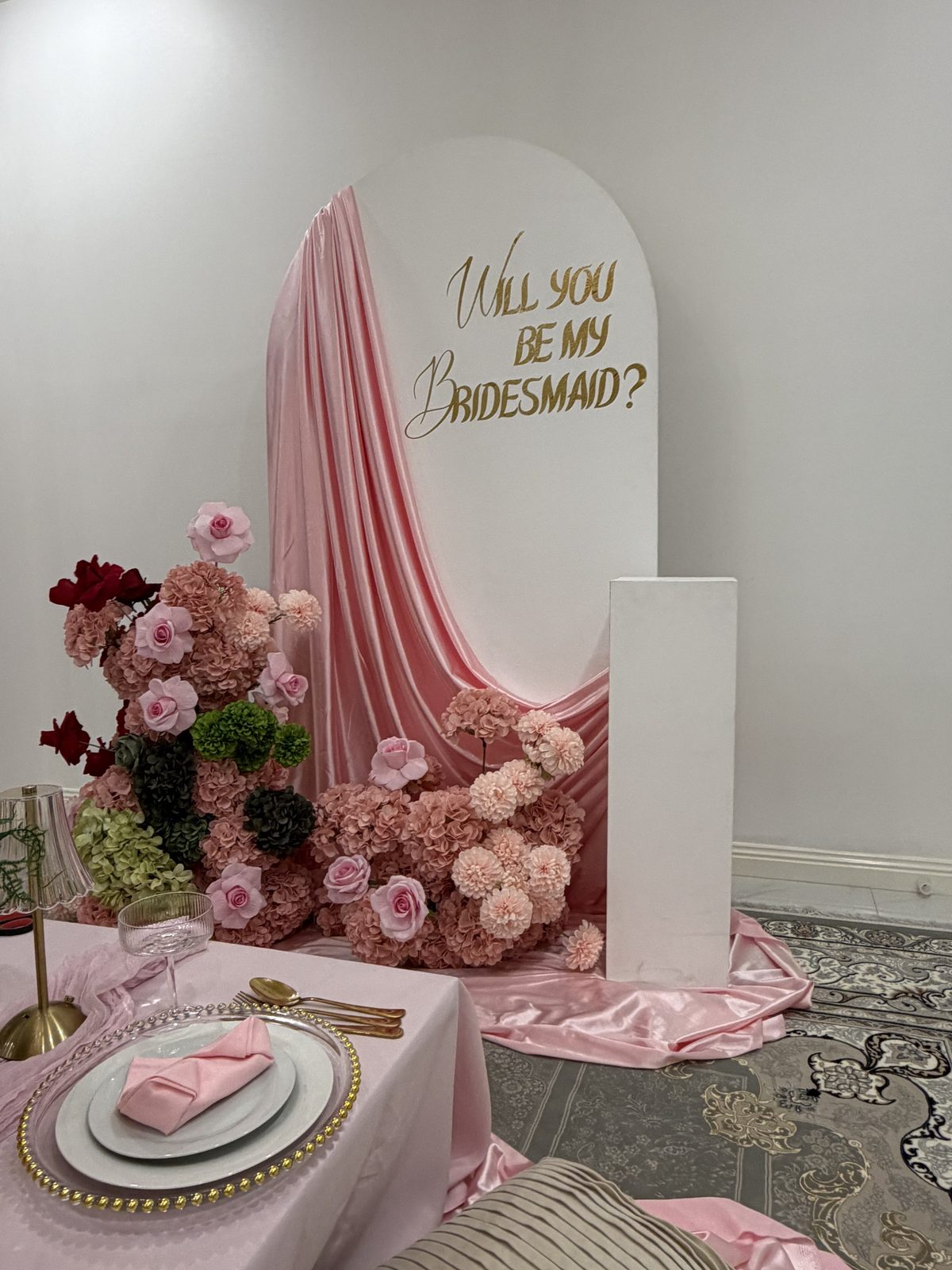 Will you be my bridesmaid arch backdrop with pink satin drape and blush florals