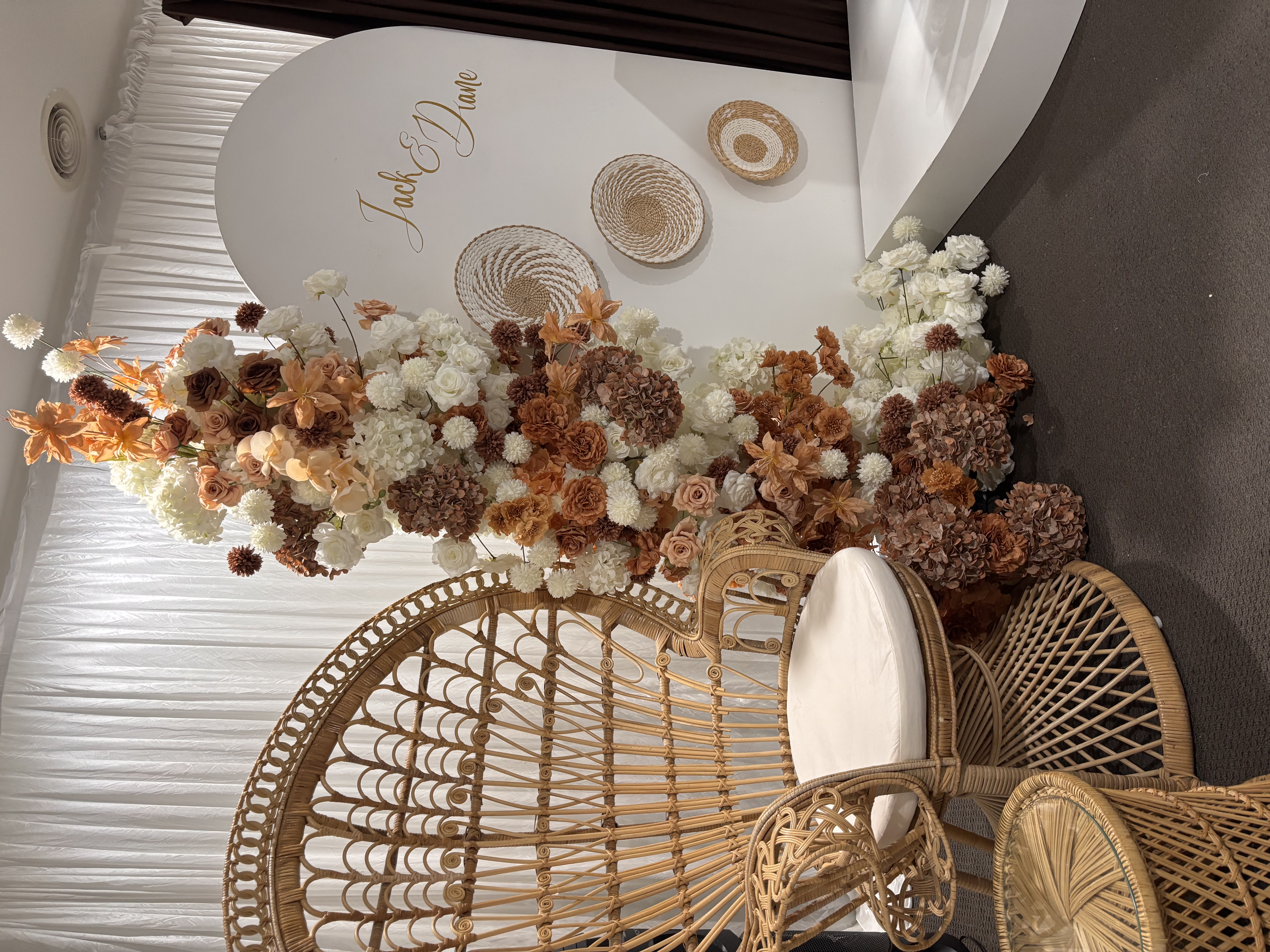 Both peacock chairs with autumn floral runner and Jack and Diane round backdrop