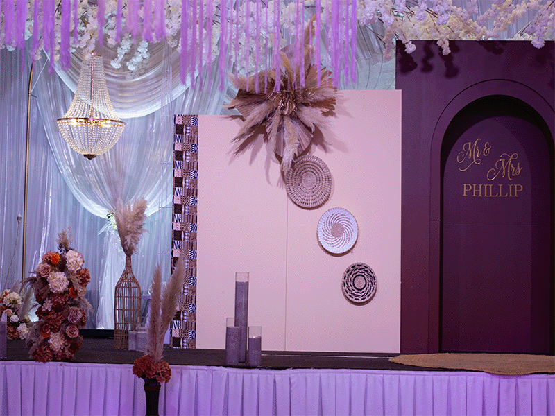 Pink and white boho wedding stage with pampas grass and woven plates